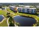 Scenic aerial view of residential buildings along a lush golf course and a tranquil pond at 4570 Pinebrook Cir # 406, Bradenton, FL 34209