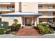 Inviting building entrance with brick pathway and lush floral landscaping at 4570 Pinebrook Cir # 406, Bradenton, FL 34209
