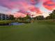 A scenic golf course and pond view is featured under a vibrant sunset sky at 4570 Pinebrook Cir # 406, Bradenton, FL 34209