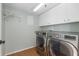 Well-equipped laundry room with modern washer and dryer, storage cabinets, and shelving at 4570 Pinebrook Cir # 406, Bradenton, FL 34209