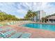 Community pool featuring lounge chairs, well-maintained pool deck, and tropical landscape at 4570 Pinebrook Cir # 406, Bradenton, FL 34209