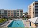 Sunny swimming pool surrounded by lounge chairs and manicured landscaping at residential complex at 4570 Pinebrook Cir # 406, Bradenton, FL 34209