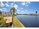 Waterfront backyard with a deck, lawn, and dock, offering serene views and direct water access at 520 Ideal Pl, North Port, FL 34287