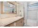 Bright bathroom with a white sink vanity, decorative mirror, and tiled shower and bathtub combination at 520 Ideal Pl, North Port, FL 34287