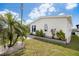 Attractive home exterior with well-maintained lawn and landscaping, including a decorative palm tree feature at 520 Ideal Pl, North Port, FL 34287