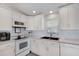 Kitchen features white cabinetry, modern stainless steel appliances, and a large window for natural light at 520 Ideal Pl, North Port, FL 34287