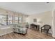 Comfortable home office with an accent chair, desk, and natural light from the multiple windows at 5264 Lake Village Dr # 48, Sarasota, FL 34235