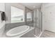 Bathroom featuring a soaking tub, glass enclosed shower, and tiled walls at 5811 Campina Pl, Palmetto, FL 34221