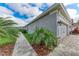 Home exterior featuring attached garage, lush landscaping, and walkway at 5811 Campina Pl, Palmetto, FL 34221