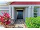 Inviting front entrance with a decorative door, pillars, and colorful landscaping at 5811 Campina Pl, Palmetto, FL 34221