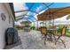 Screened in patio featuring a grill, seating, and beautiful lake views at 5811 Campina Pl, Palmetto, FL 34221