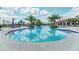 Resort-style pool surrounded by palm trees, lounge chairs, and seating areas at 5811 Campina Pl, Palmetto, FL 34221