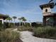 Community entrance with lush landscaping, pavers, and tile-roofed tower provides a welcoming scene at 5952 Snowy Egret Dr, Sarasota, FL 34238