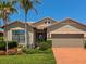 Charming home with manicured lawn, lush landscaping, brick driveway and two-car garage at 5952 Snowy Egret Dr, Sarasota, FL 34238