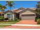 Charming home exterior with a well-maintained lawn and brick driveway at 5952 Snowy Egret Dr, Sarasota, FL 34238