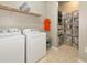 Laundry room featuring modern appliances and shelving at 5952 Snowy Egret Dr, Sarasota, FL 34238