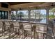 This outdoor bar features stylish seating and counterspace with a view of the community pool and tropical landscaping at 5952 Snowy Egret Dr, Sarasota, FL 34238