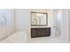 Bright bathroom featuring soaking tub, elegant dark wood vanity and tiled floor at 600 Blue Shell Loop, Sarasota, FL 34240
