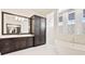 Bright bathroom with tiled shower, garden tub, and a dark wood storage cabinet at 600 Blue Shell Loop, Sarasota, FL 34240