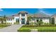 Beautiful home with a grey brick driveway, tropical landscaping, and grey shingled roof at 600 Blue Shell Loop, Sarasota, FL 34240