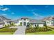 Beautiful home with a grey brick driveway, tropical landscaping, and grey shingled roof at 600 Blue Shell Loop, Sarasota, FL 34240