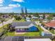 Backyard view featuring a blue single-story home with a patio and sunroom with surrounding landscaping and partial fencing at 6004 10Th Ave W, Bradenton, FL 34209