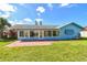 Exterior back view of home featuring a sunroom, grassy yard, and brick patio at 6004 10Th Ave W, Bradenton, FL 34209