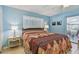 Bedroom with blue walls, bed, shuttered window and access to sun room at 6004 10Th Ave W, Bradenton, FL 34209