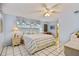 Inviting bedroom with a ceiling fan, striped bedding, and ample natural light at 6004 10Th Ave W, Bradenton, FL 34209