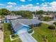 Beautiful blue single-story home with a lush green lawn, attached garage, and well-maintained landscaping at 6004 10Th Ave W, Bradenton, FL 34209