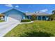 Charming blue single-story home featuring a well-manicured lawn and an attached two-car garage at 6004 10Th Ave W, Bradenton, FL 34209