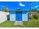 Blue shed with double doors on a lawn featuring a wooden walkway to the entrance at 6004 10Th Ave W, Bradenton, FL 34209