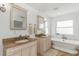 Bright bathroom featuring double vanities, a standalone tub, and plenty of natural light at 6015 S Elkins Ave, Tampa, FL 33611