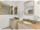 Bright bathroom featuring dual sinks, granite countertops, and decorative glass block windows for natural light at 6015 S Elkins Ave, Tampa, FL 33611