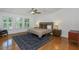 Serene main bedroom with hardwood floors, a cozy rug, and abundant natural light from large windows at 6015 S Elkins Ave, Tampa, FL 33611