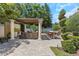 Backyard outdoor kitchen with built-in grill, mini-fridge, and seating area under a pergola at 6015 S Elkins Ave, Tampa, FL 33611