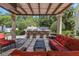 Beautiful outdoor area featuring a large dining table, comfortable seating, and a covered pergola for relaxation and entertaining at 6015 S Elkins Ave, Tampa, FL 33611