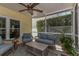 Inviting screened patio featuring comfortable wicker seating, a ceiling fan, and lush tropical plants at 6015 S Elkins Ave, Tampa, FL 33611
