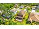Aerial shot of the house showcasing the back patio with an outdoor kitchen, grassy yard, and well maintained landscaping at 6111 Horse Mill Pl, Palmetto, FL 34221