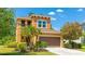 A charming two-story home features a two-car garage, stucco exterior, and well-manicured landscaping at 6111 Horse Mill Pl, Palmetto, FL 34221