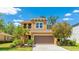 Beautiful two-story home with a well-manicured lawn, mature trees, and a two car garage at 6111 Horse Mill Pl, Palmetto, FL 34221
