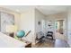 Upstairs hallway featuring decorative accents and doorway access to a bedroom with natural lighting at 6111 Horse Mill Pl, Palmetto, FL 34221