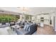 Open-concept living room featuring a large sectional sofa, modern lighting, and seamless access to the outdoor space at 6111 Horse Mill Pl, Palmetto, FL 34221