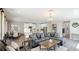 Bright living room with a large sectional sofa, modern lighting fixture, and an open layout leading to the kitchen at 6111 Horse Mill Pl, Palmetto, FL 34221