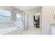 Luxurious main bathroom featuring a soaking tub, glass shower, and walk-in closet at 6111 Horse Mill Pl, Palmetto, FL 34221