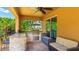 Covered outdoor kitchen with granite countertops, stone accents, grill, seating, and a nearby outdoor sofa area at 6111 Horse Mill Pl, Palmetto, FL 34221