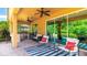Outdoor kitchen and living area with grill, ceiling fans, outdoor seating, and sliding glass doors to the home's interior at 6111 Horse Mill Pl, Palmetto, FL 34221