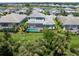 The aerial view reveals the backyard oasis with a pool and tropical landscaping at 6317 Rivo Lakes Blvd, Sarasota, FL 34241