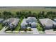 An aerial view captures the meticulously landscaped property with a gray roof and lush surroundings at 6317 Rivo Lakes Blvd, Sarasota, FL 34241