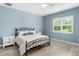 Comfortable bedroom with light blue walls, wood-look floors, a queen bed, and bright window at 6317 Rivo Lakes Blvd, Sarasota, FL 34241